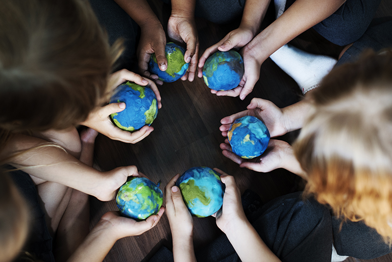 group of diverse kids hands holding globes