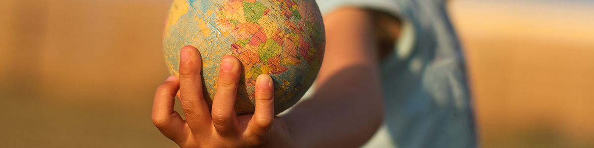 child hand holding an earth toy globe