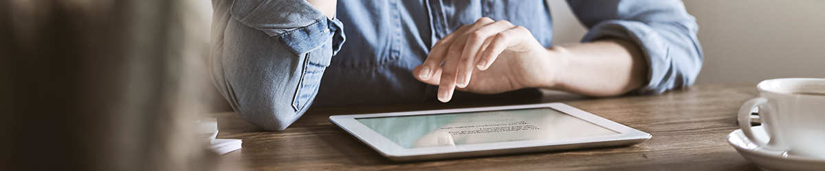 young woman sitting at home working online with a tablet